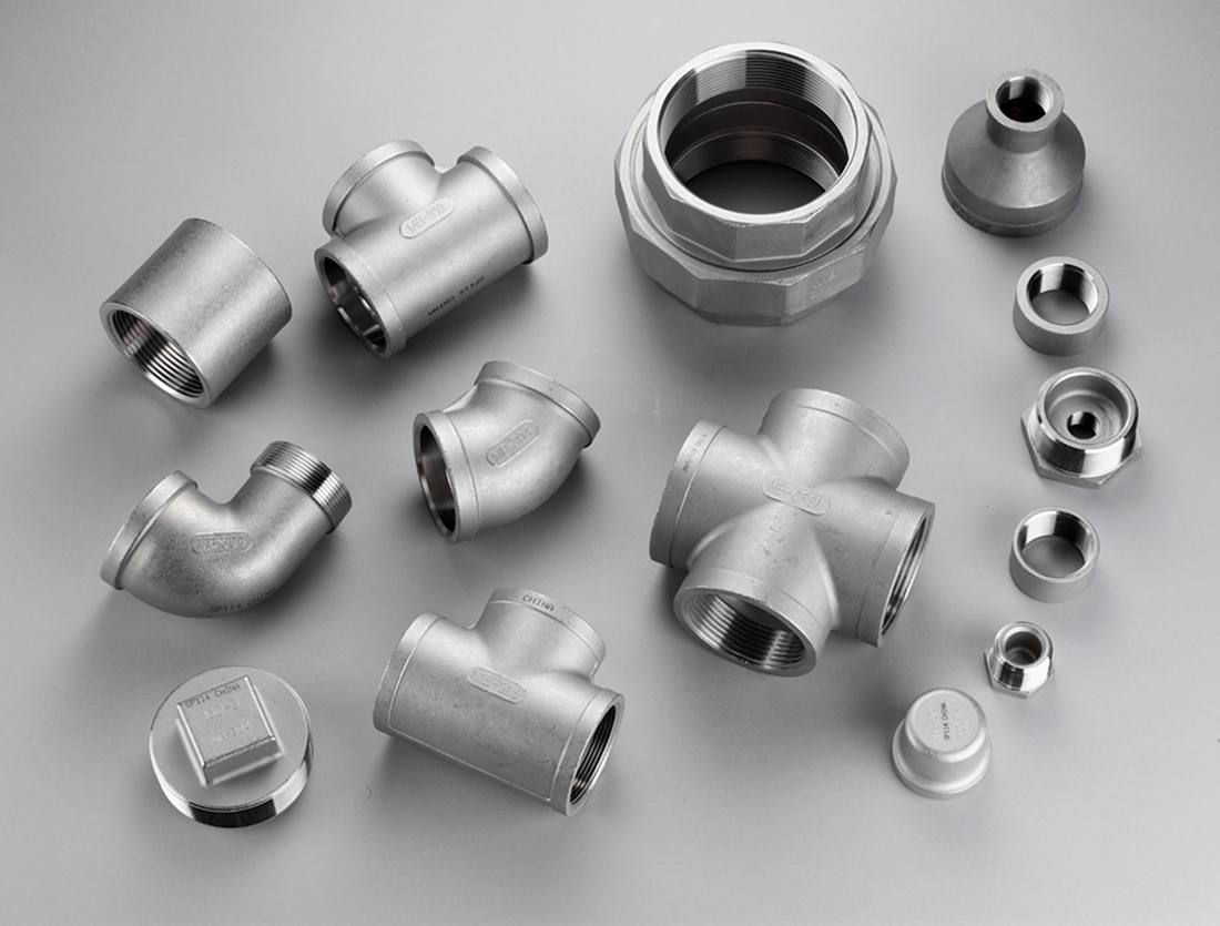 MSS SP-114 stainless steel fittings arranged across a gray surface